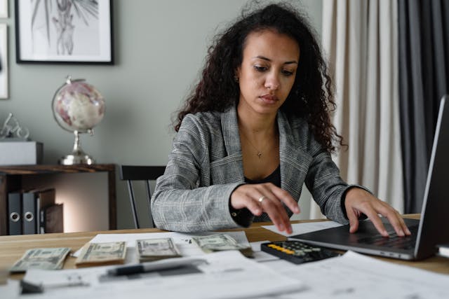 Lady With Laptop and Money- calculating payroll