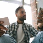 Man looking at mobile with cards in hand